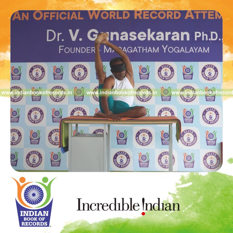 an individual holding daksina purna krounchasana yoga pose blindfolded on a table continuously for the longest duration with balance and control for a record in Indian Book of Records