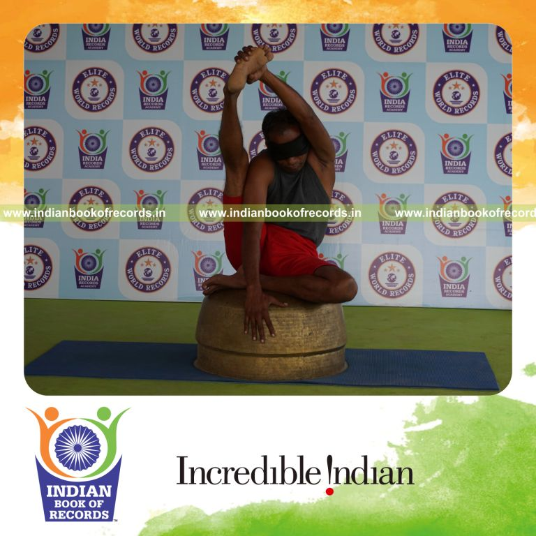 individual holding daksina purna krounchasana yoga pose blindfolded on a vessel for record in Indian Book of Records
