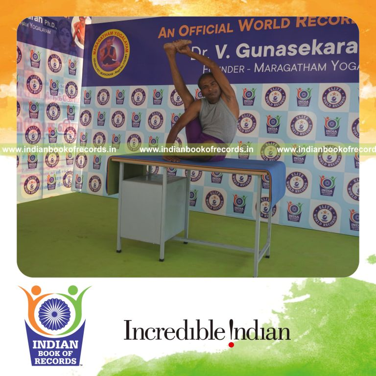 individual holding daksina purna krounchasana yoga pose on a table for record in Indian Book of Records