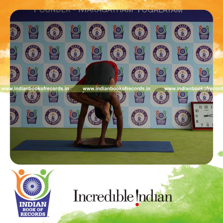 individual holding daksina ruchikasana yoga pose blindfolded on a brass plate for record in Indian Book of Records