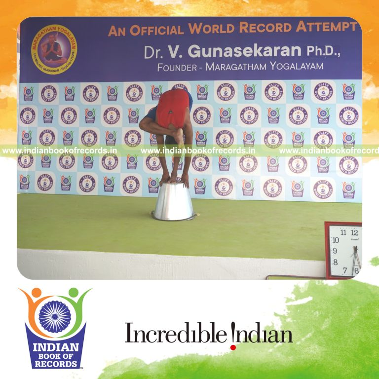 individual holding daksina ruchikasana yoga pose on a bucket for record in Indian Book of Records