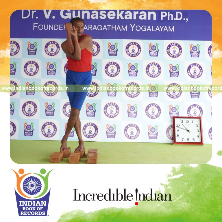 individual holding daksina tada garudasana yoga pose on bricks for record in Indian Book of Records