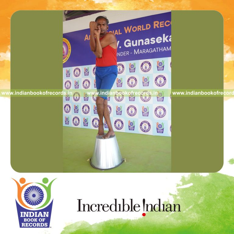 individual holding daksina tada garudasana yoga pose on a bucket for record in Indian Book of Records