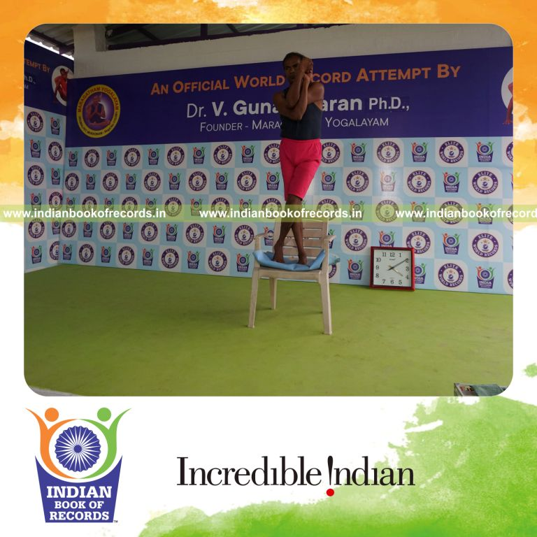 individual holding daksina tada garudasana yoga pose on a chair for record in Indian Book of Records