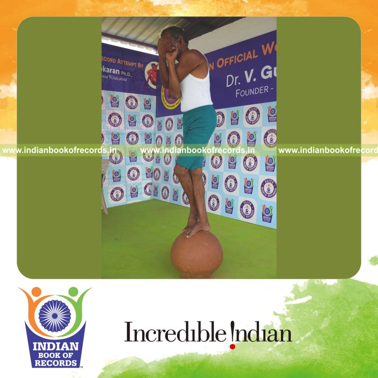 individual holding daksina tada garudasana yoga pose on a pot for record in Indian Book of Records