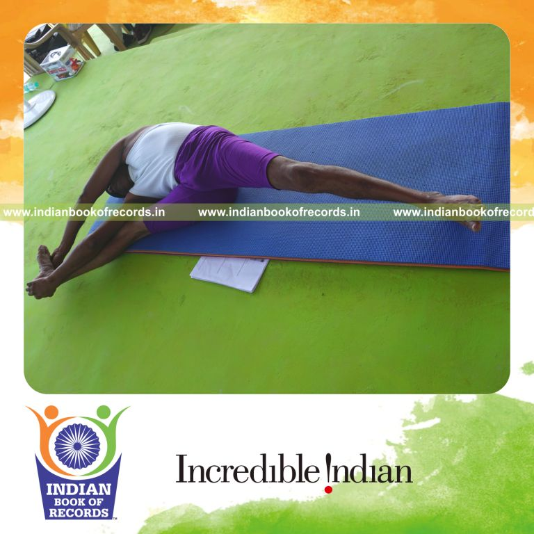 individual holding daksina trivikramasana yoga pose blindfolded for record in Indian Book of Records