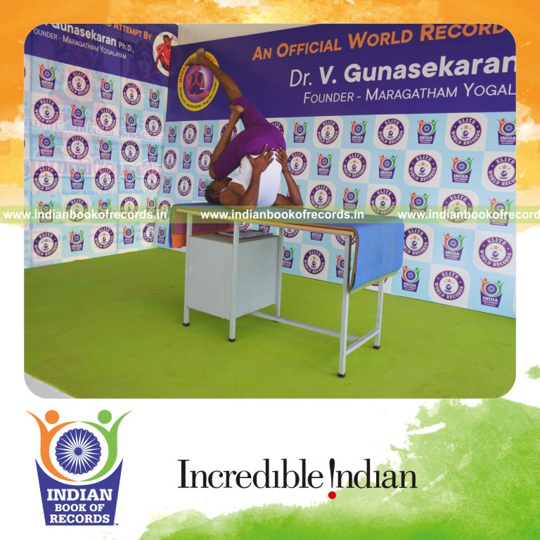 individual holding daksina utthita kadi ekapada chakrasana yoga pose on a table for record in Indian Book of Records