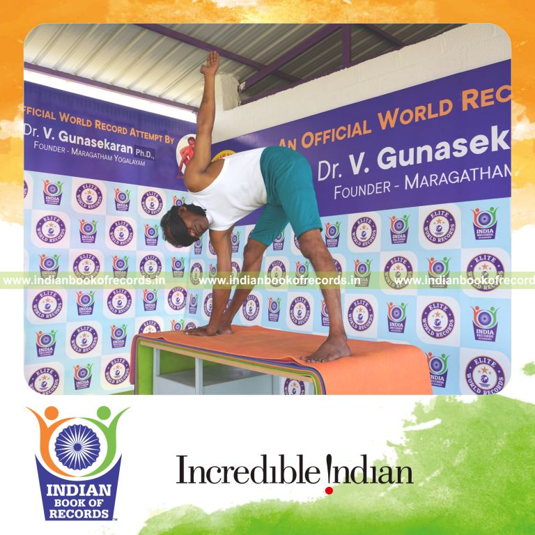 an individual holding daksina utthita trikonasana yoga pose blindfolded on a table continuously for the longest duration with stability and control for a record in Indian Book of Records