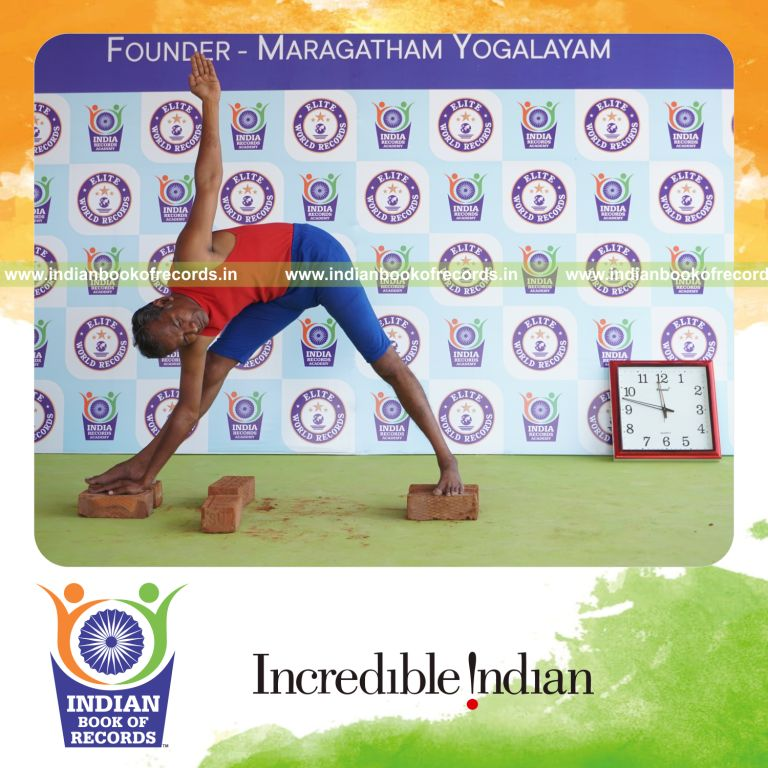 individual holding daksina utthita trikonasana yoga pose on bricks for record in Indian Book of Records