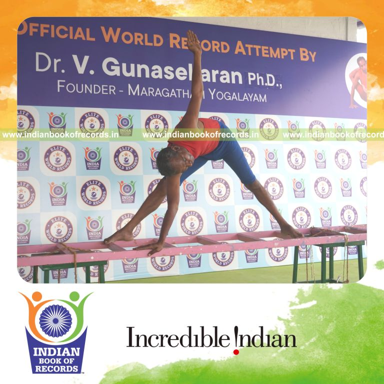 individual holding daksina utthita trikonasana yoga pose on a ladder for record in Indian Book of Records