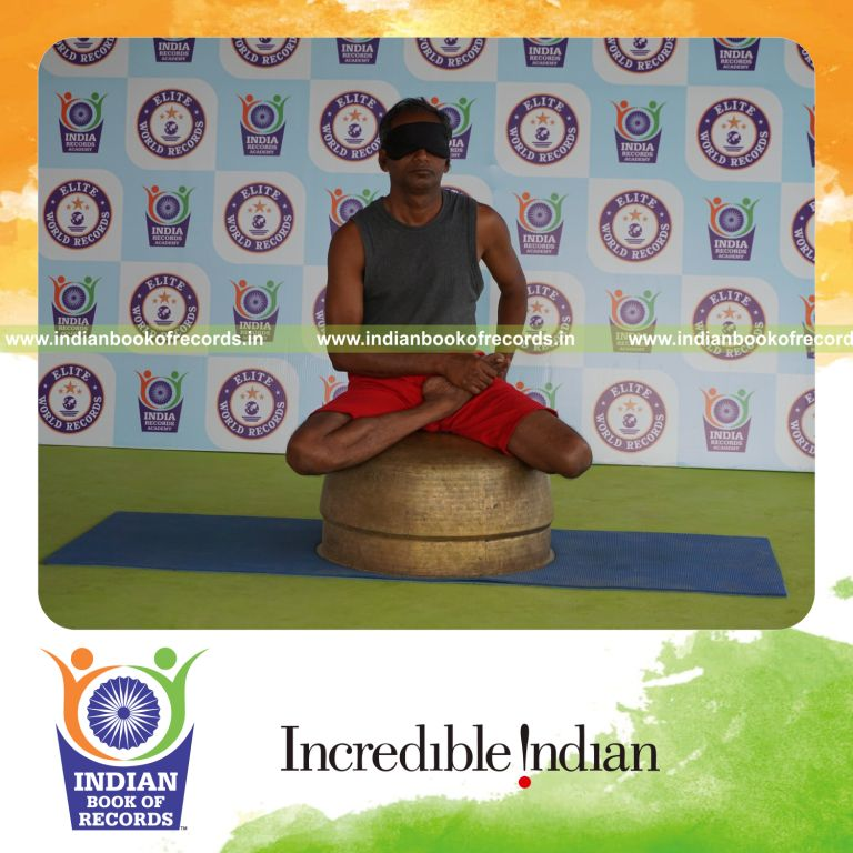 individual holding daksina vamadevasana yoga pose blindfolded on a vessel for record in Indian Book of Records