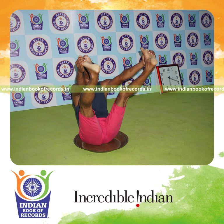 individual holding enkonasana yoga pose on a brass plate for record in Indian Book of Records