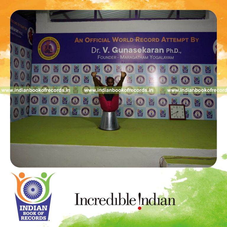 individual holding enkonasana yoga pose on a bucket for record in Indian Book of Records