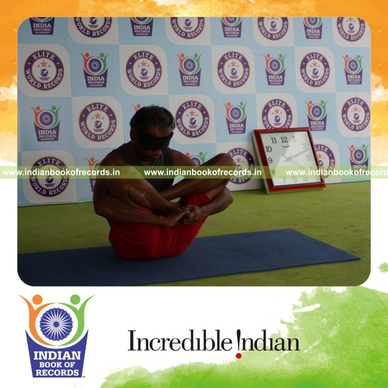 individual holding garbha pindasana yoga pose blindfolded for record in Indian Book of Records