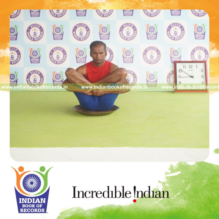 individual holding garbha pindasana yoga pose on a brass plate for record in Indian Book of Records