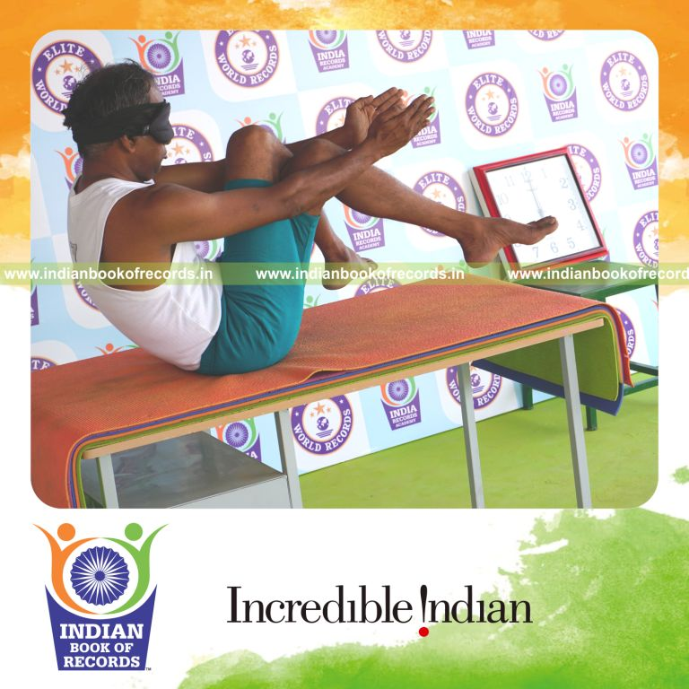 an individual holding garuda navasana yoga pose blindfolded on a table continuously for the longest duration with balance and control for a record in Indian Book of Records