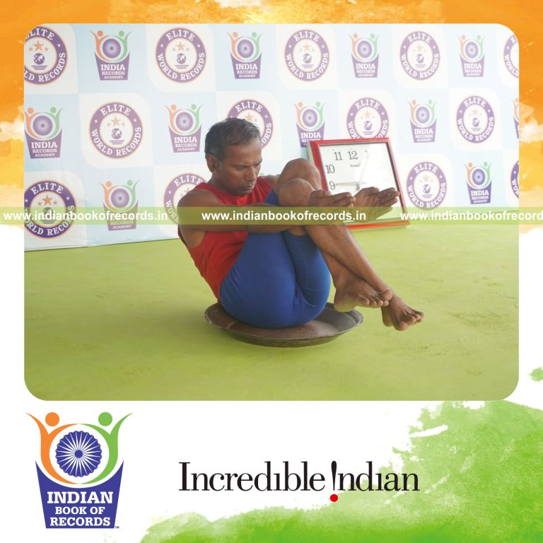 individual holding garuda navasana yoga pose on a brass plate for record in Indian Book of Records