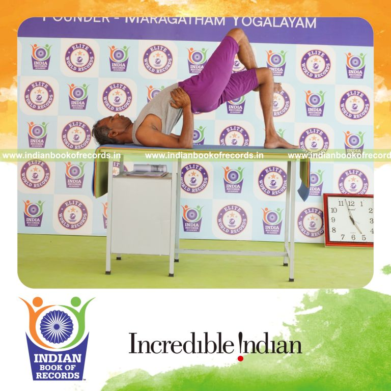 individual holding garuda setu bandha sarvangasana yoga pose on a table for record in Indian Book of Records