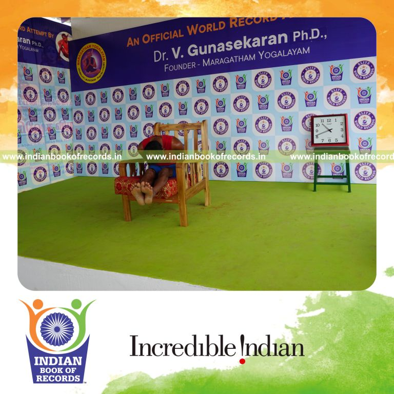 individual holding gopura paschimottanasana yoga pose on a chair for record in Indian Book of Records