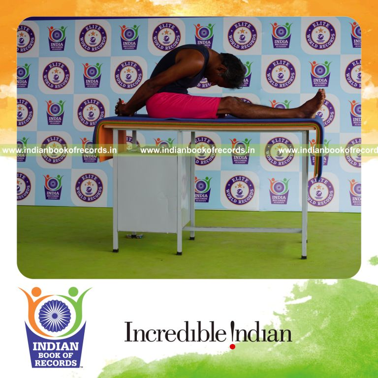 individual holding gopura paschimottanasana yoga pose on a table for record in Indian Book of Records