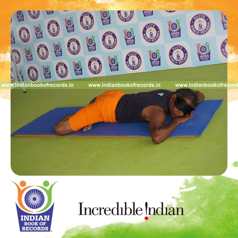 individual holding guptasana yoga pose blindfolded for record in Indian Book of Records