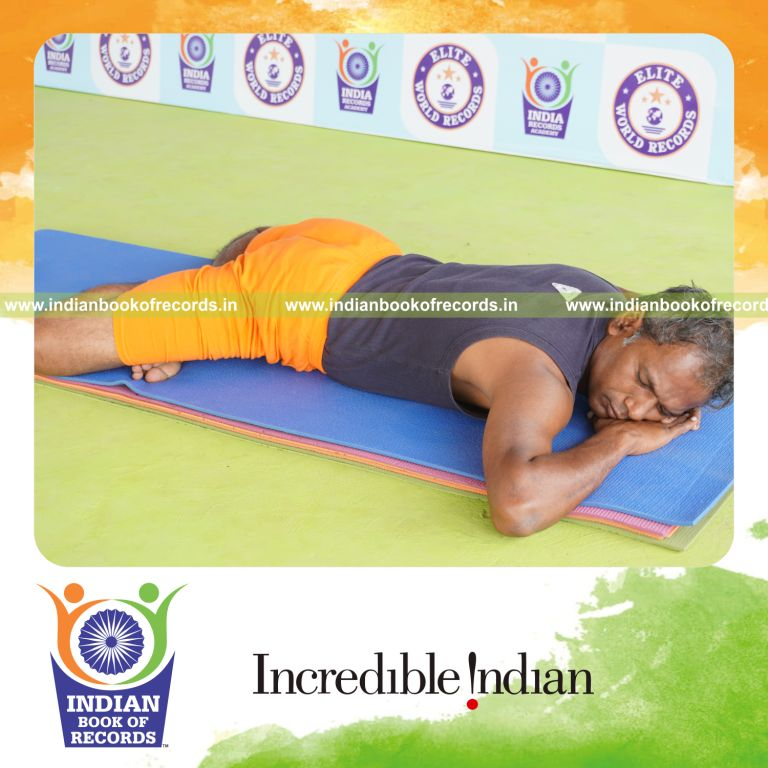 individual holding guptasana yoga pose for record in Indian Book of Records