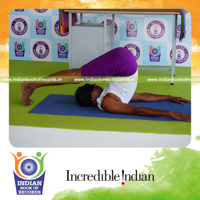 individual holding halasana yoga pose blindfolded for record in Indian Book of Records