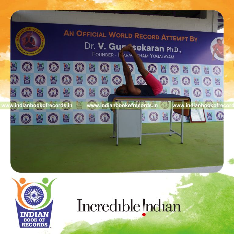 individual holding julasana yoga pose on a table for record in Indian Book of Records