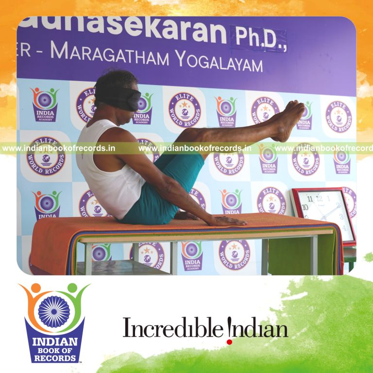 an individual holding navasana yoga pose blindfolded on a table continuously for the longest duration with balance and control for a record in Indian Book of Records