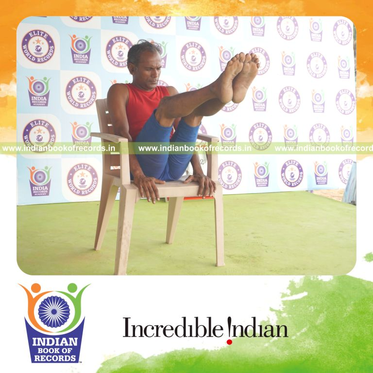 individual holding navasana yoga pose on a chair for record in Indian Book of Records