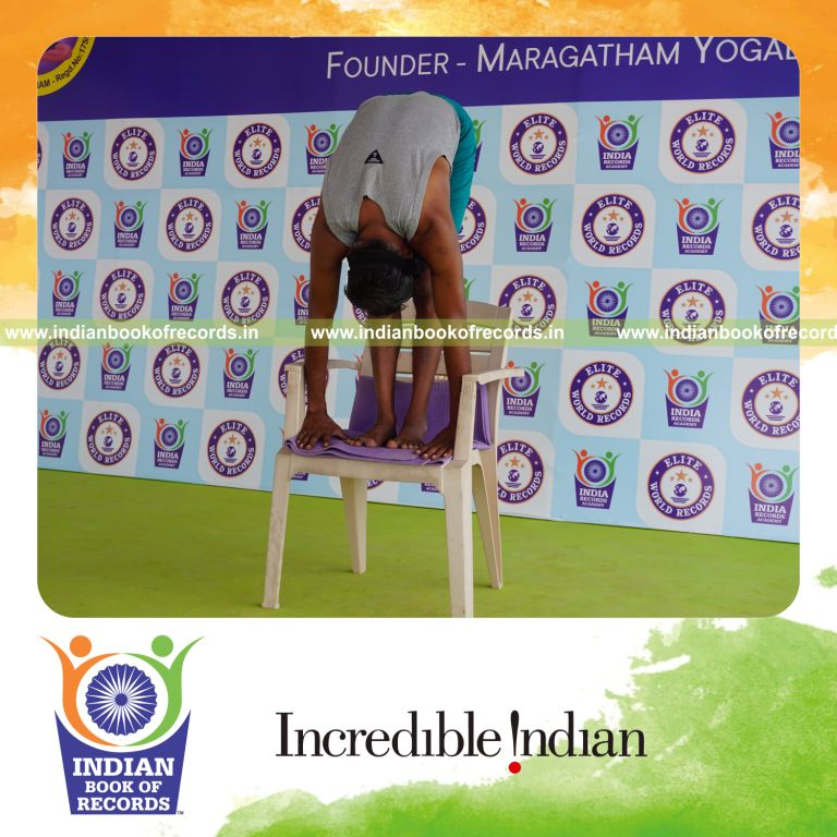 individual holding padahasthasana yoga pose blindfolded on a chair for record in Indian Book of Records