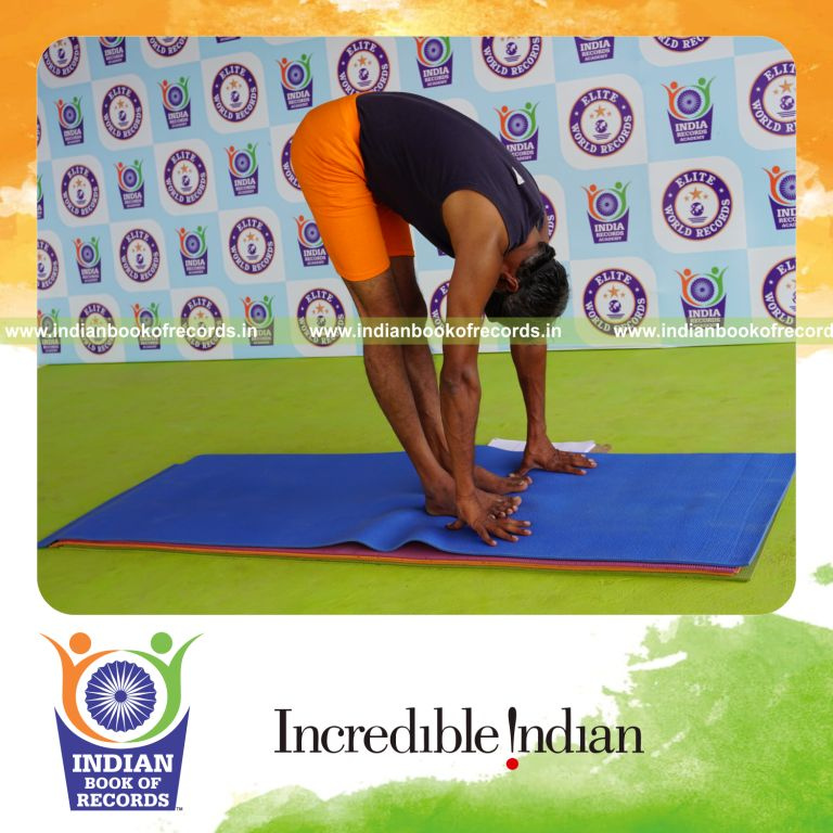 individual holding padahasthasana yoga pose blindfolded for record in Indian Book of Records
