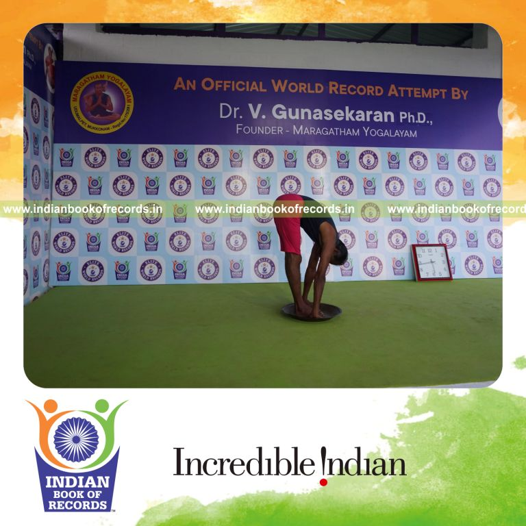 individual holding padahasthasana yoga pose on a brass plate for record in Indian Book of Records