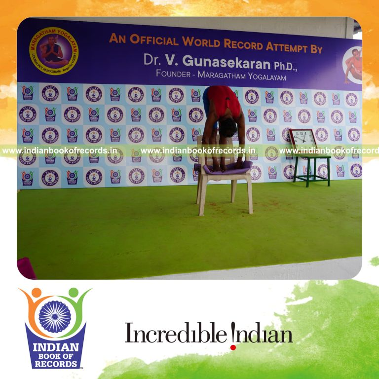 individual holding padahasthasana yoga pose on a chair for record in Indian Book of Records