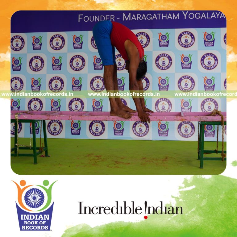 individual holding padahasthasana yoga pose on a ladder for record in Indian Book of Records