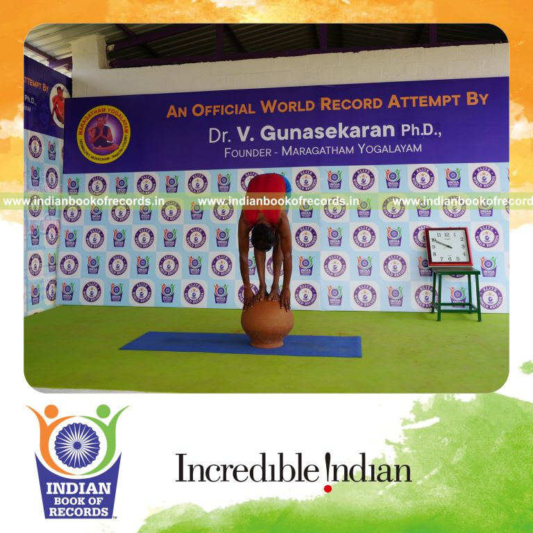 individual holding padahasthasana yoga pose on a pot for record in Indian Book of Records