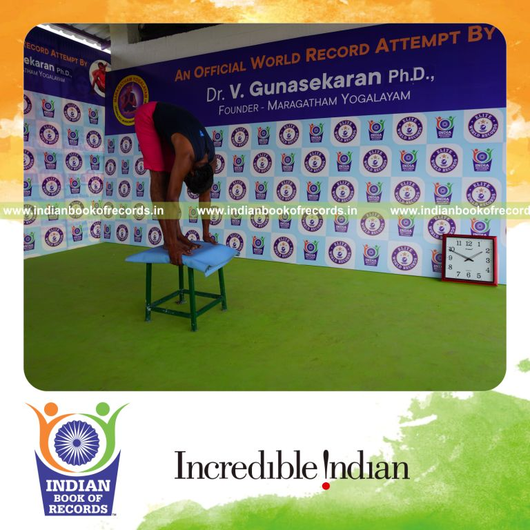 individual holding padahasthasana yoga pose on a stool for record in Indian Book of Records