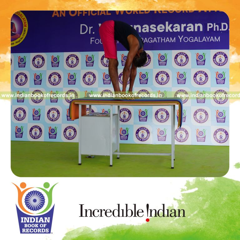 individual holding padahasthasana yoga pose on a table for record in Indian Book of Records