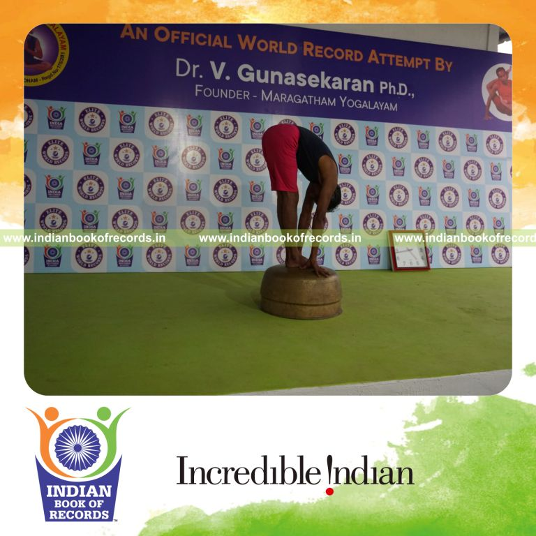 individual holding padahasthasana yoga pose on a vessel for record in Indian Book of Records