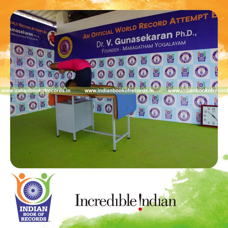 individual holding padma salamba sarvangasana yoga pose blindfolded on a table for record in Indian Book of Records