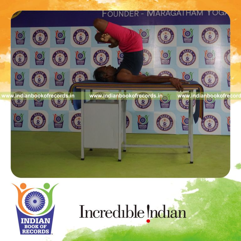 individual holding padma salamba sarvangasana yoga pose on a table for record in Indian Book of Records