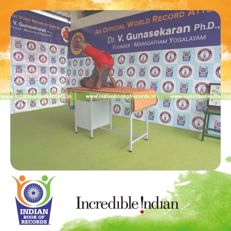 individual holding padma sarvangasana yoga pose on a table for record in Indian Book of Records