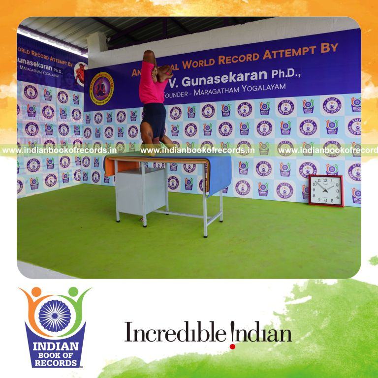individual holding padma sirsasana yoga pose on a table for record in Indian Book of Records