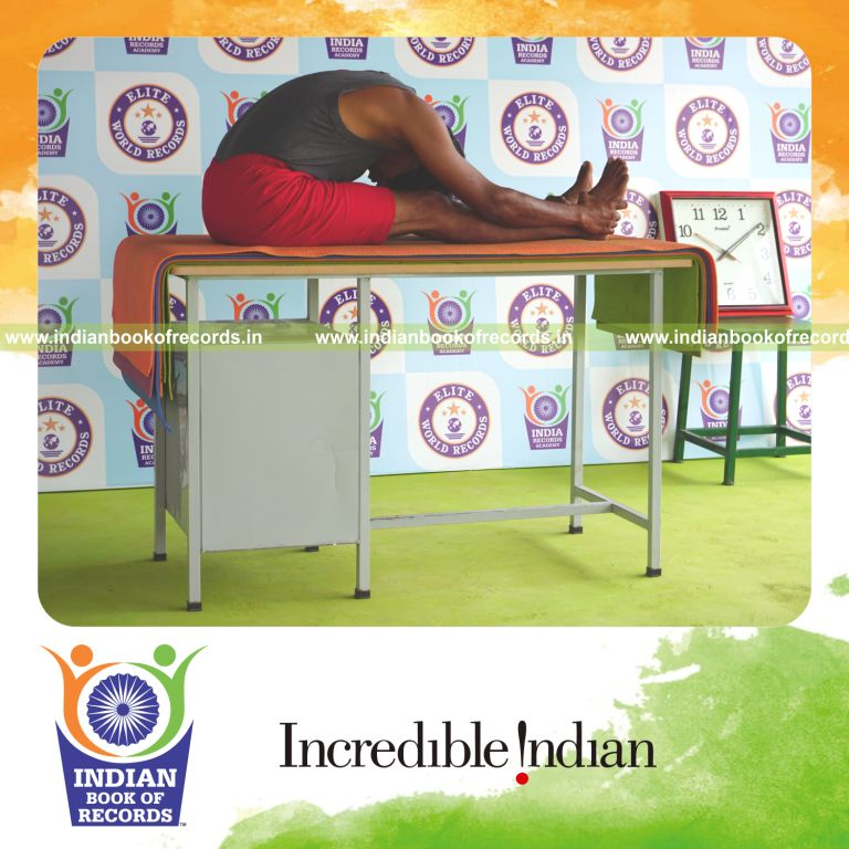 individual holding paschimottanasana yoga pose blindfolded on a table for record in Indian Book of Records