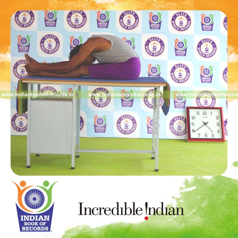 individual holding paschimottanasana yoga pose on a table for record in Indian Book of Records