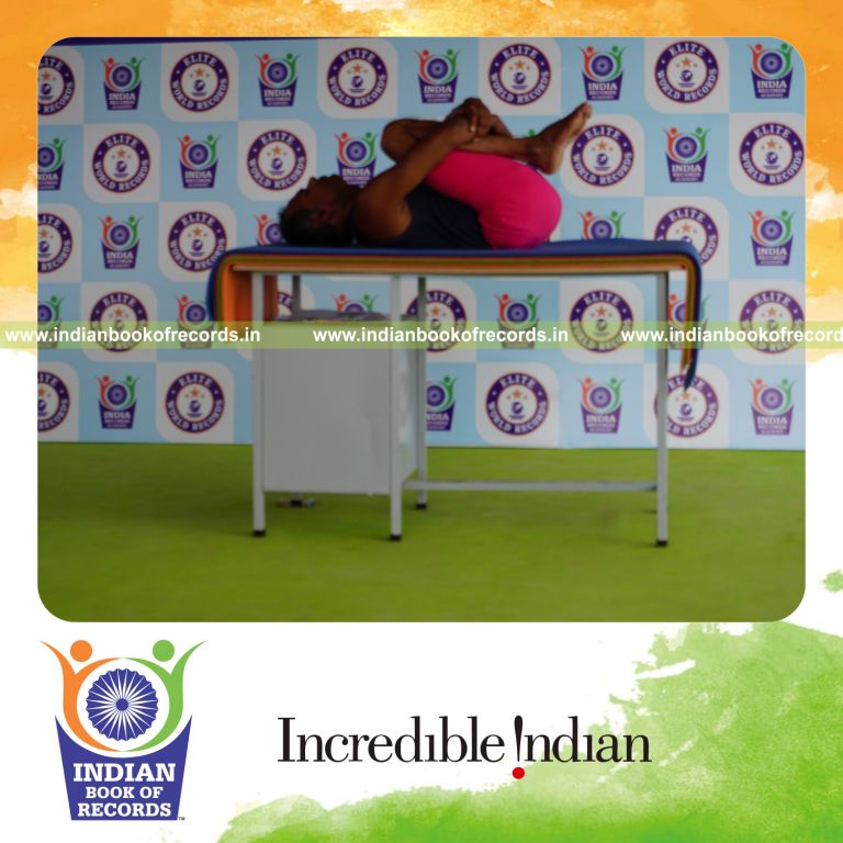 individual holding pavanamuktasana yoga pose on a table for record in Indian Book of Records
