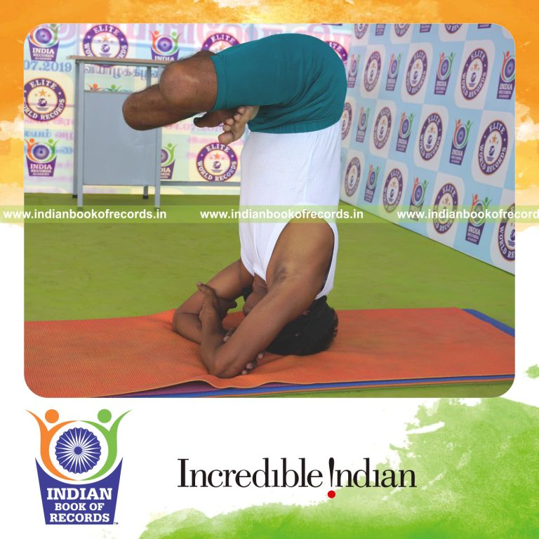 an individual holding pindasana in baddha hastha sirsasana yoga pose blindfolded continuously for the longest duration with balance and control for a record in Indian Book of Records