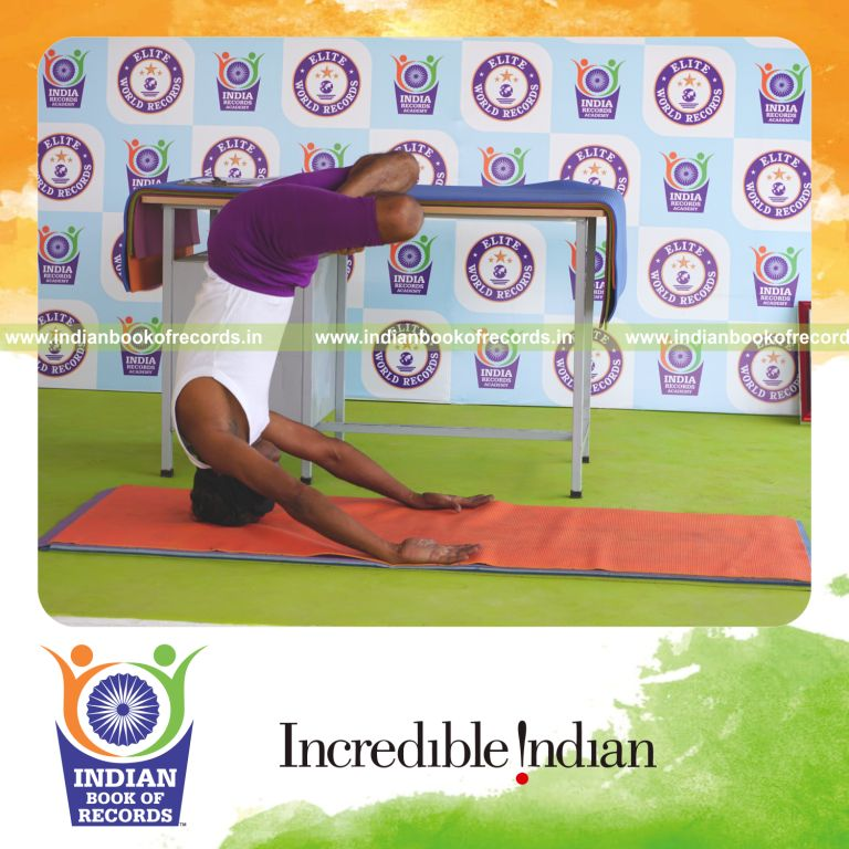 individual holding pindasana in mukta sirsasana yoga pose blindfolded for record in Indian Book of Records