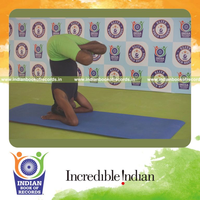 an individual holding pindasana in salamba sirsasana yoga pose blindfolded for the longest duration with control and stability for a record in Indian Book of Records