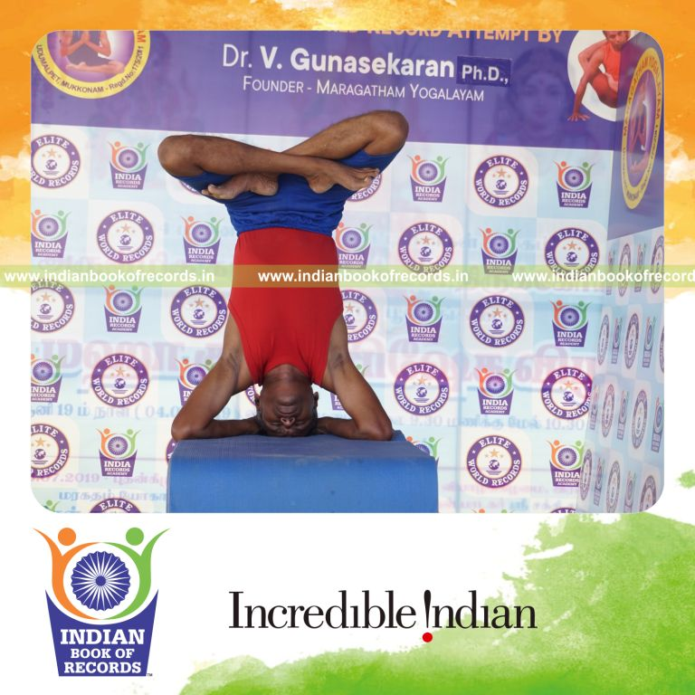 individual holding pindasana in salamba sirsasana yoga pose on a table for record in Indian Book of Records